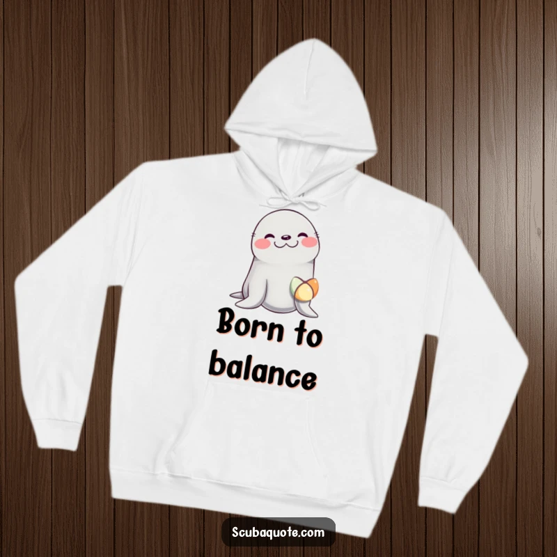 Funny hoodie showcasing a seal in fits of giggles, expertly balancing a colorful ball on its nose, promising warmth and humor.
